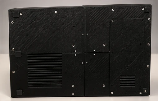 Base inferior de la carcasa: piezas negras unidas con tornillos, rejillas de ventilación y una tapa rectangular.