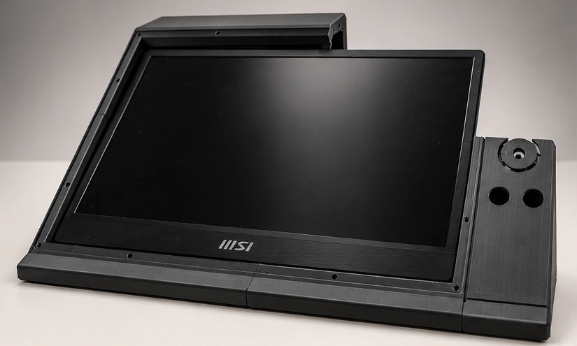 Vista frontal del prototipo: pantalla MSI apagada montada en la carcasa negra y, a la derecha, el módulo de mandos con un anillo y dos agujeros.